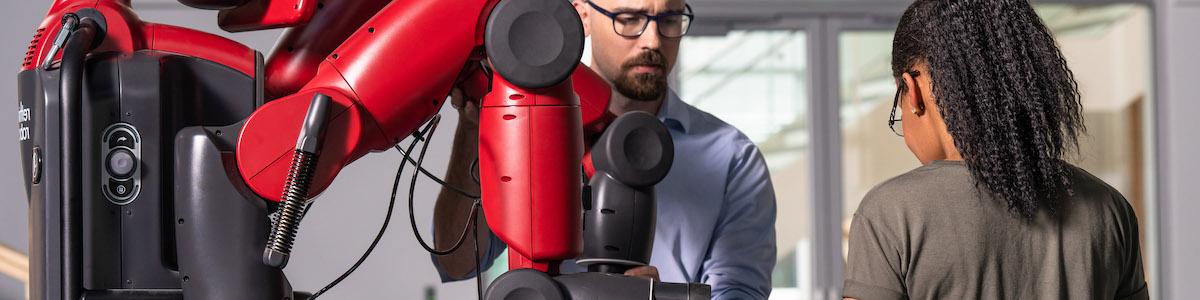 Mechanical Design Technology instructor and student working with an industrial robot